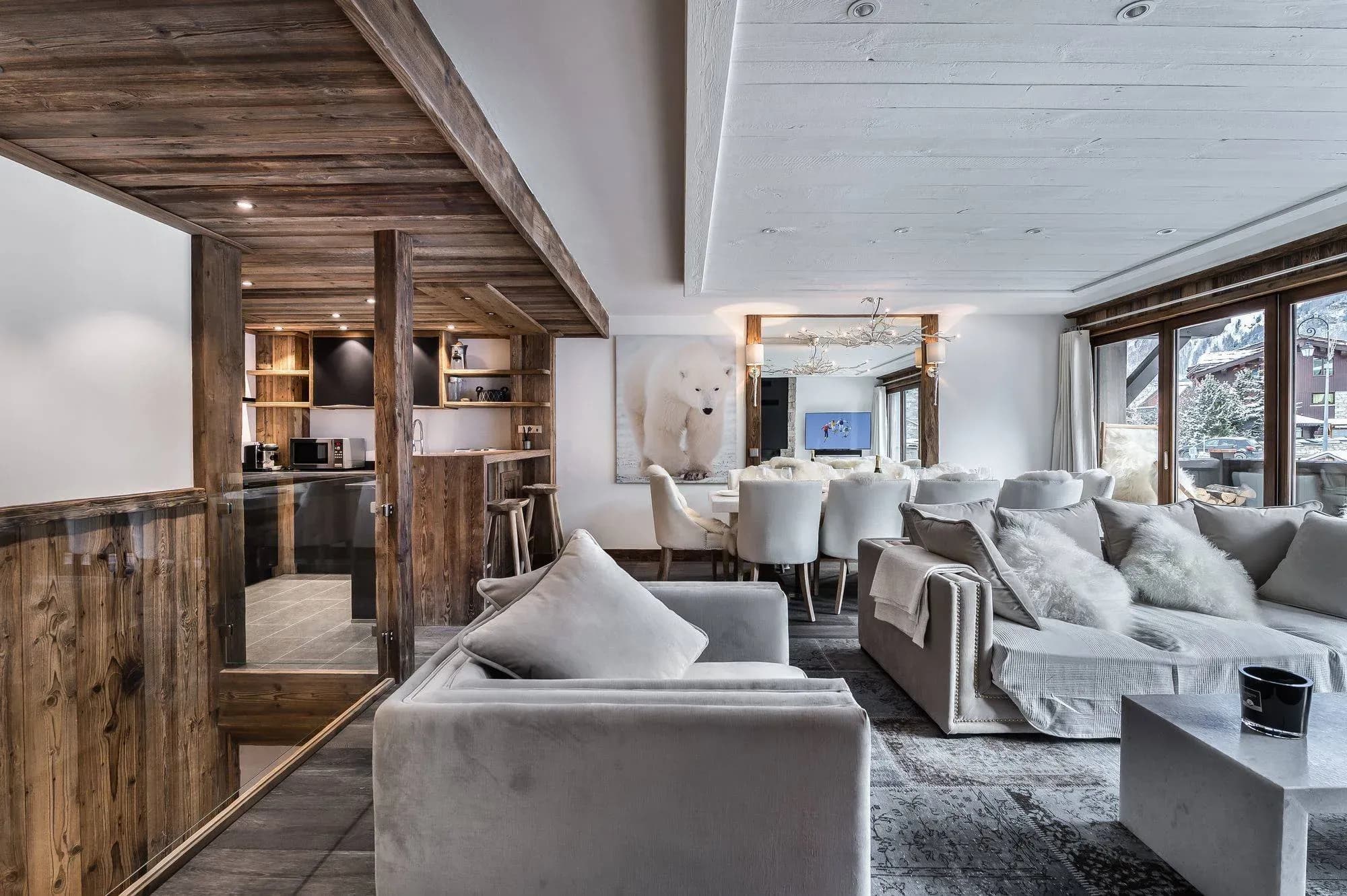 Living room with grey sofas, polar bear artwork and dining table beyond