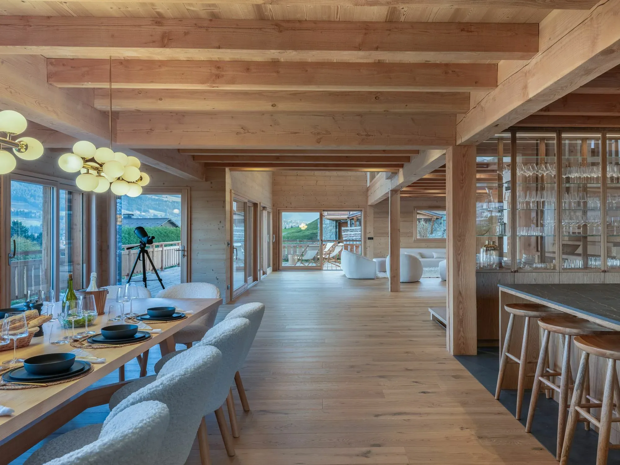 Open-plan dining table with bouclé chairs and breakfast bar with four stools