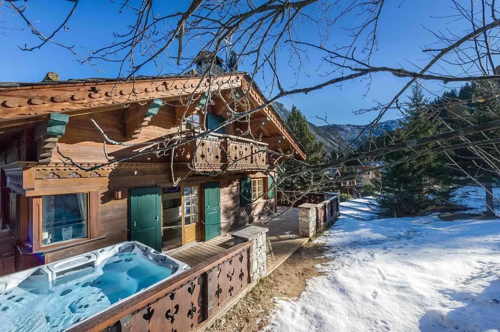 Hot tub on wooden terrace beside the chalet, with mountain view