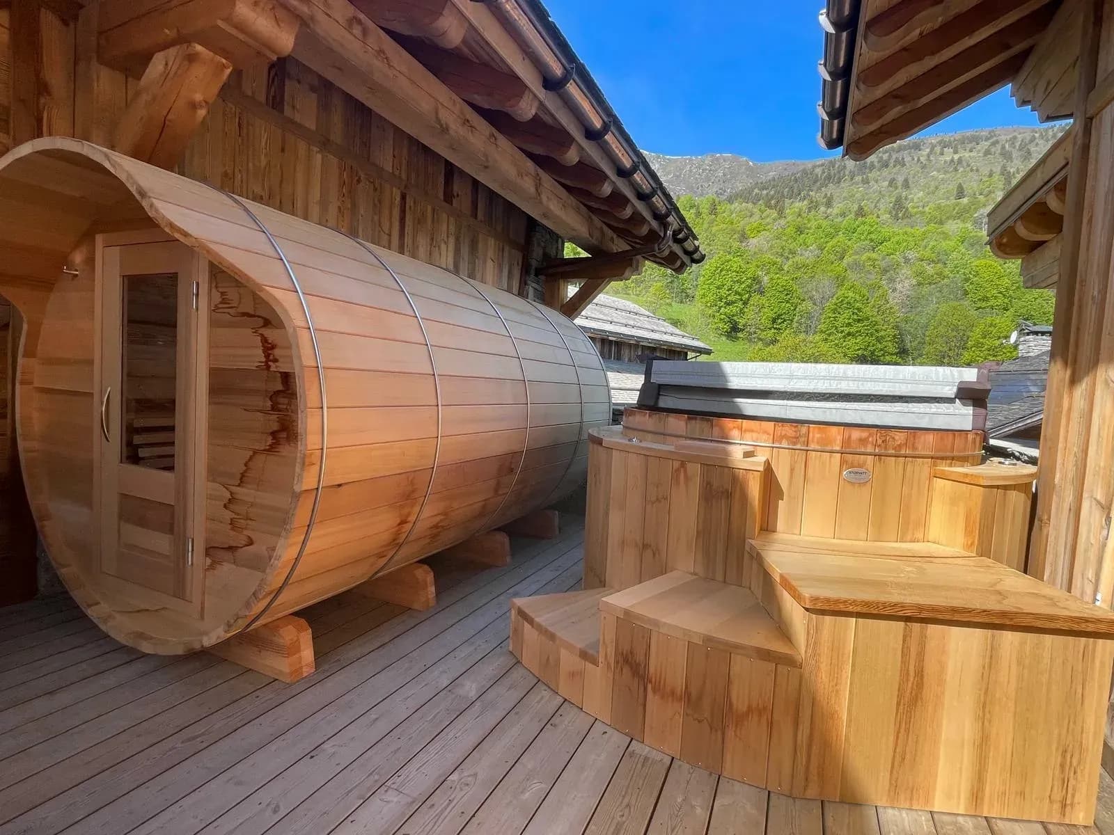 Terrace with barrel sauna and wooden hot tub facing the mountains
