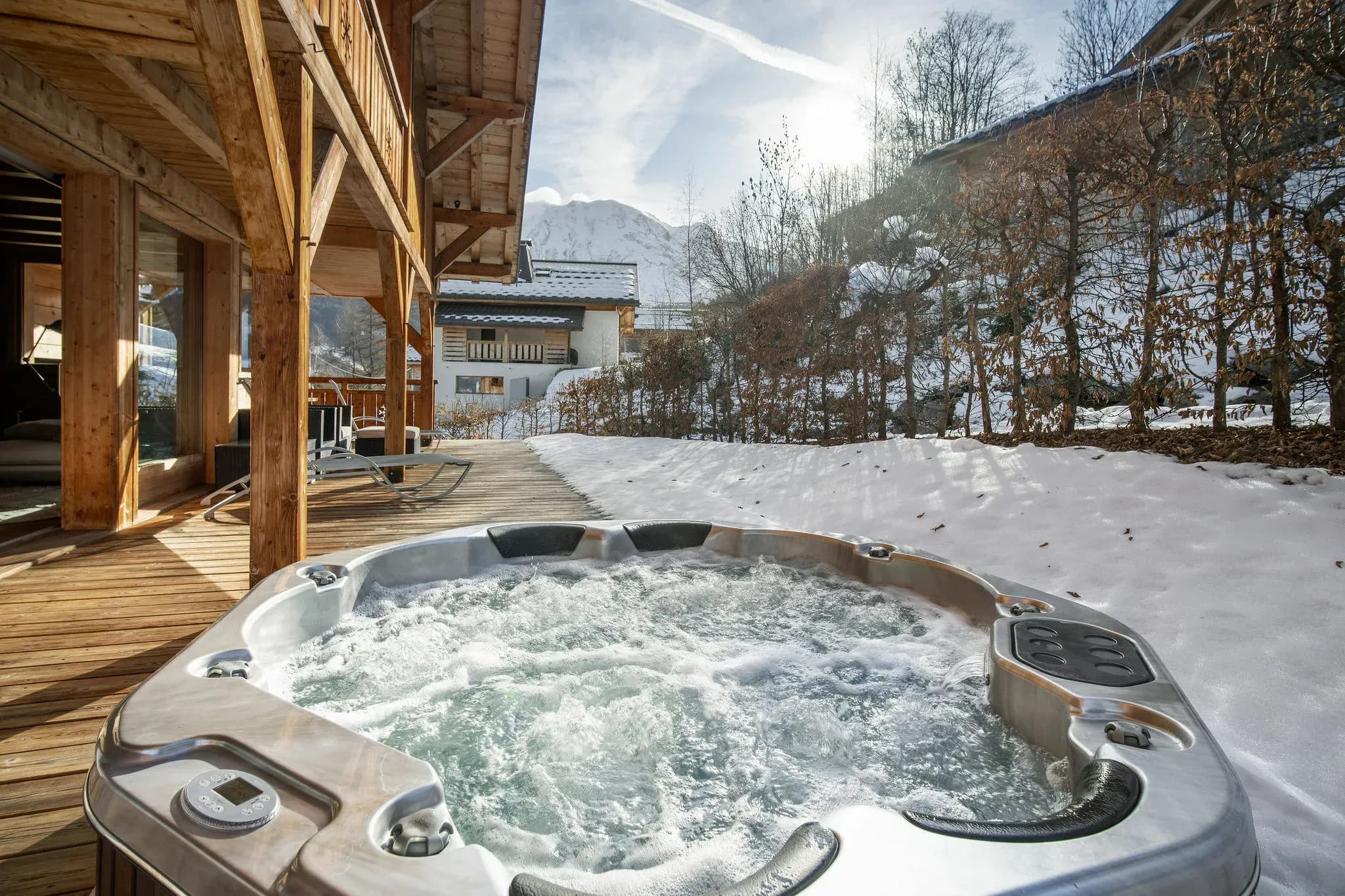 Outdoor hot tub on wooden terrace beside the chalet