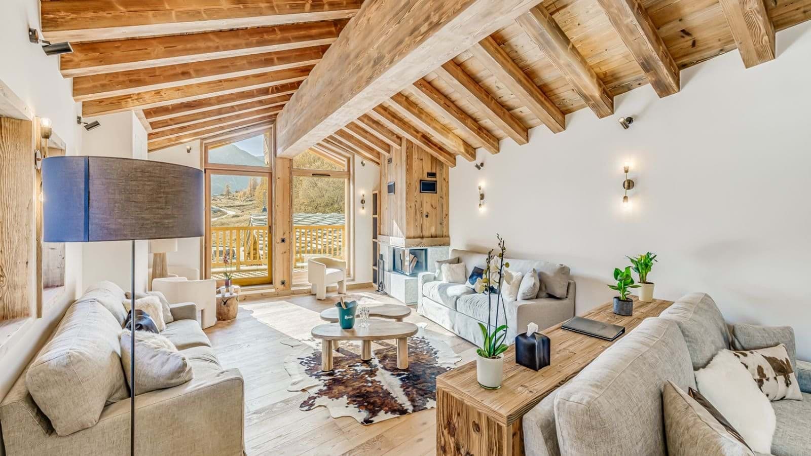 Living area with wood-burning fireplace and mountain-view balcony access