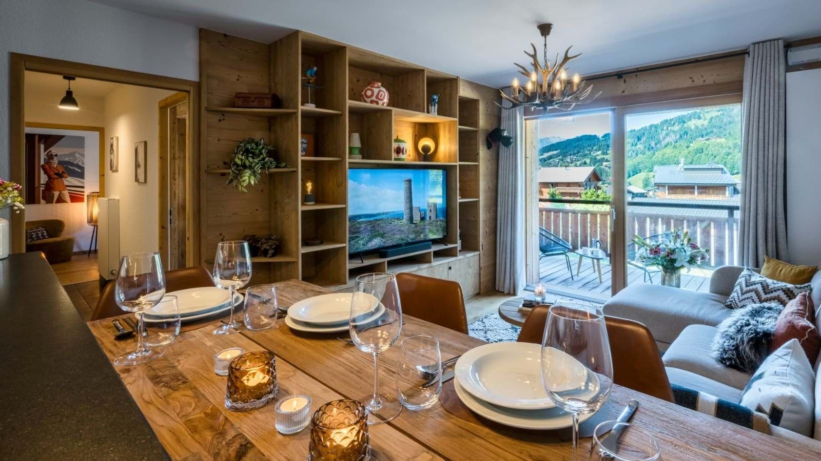 Open-plan dining and living area with balcony access and mountain views