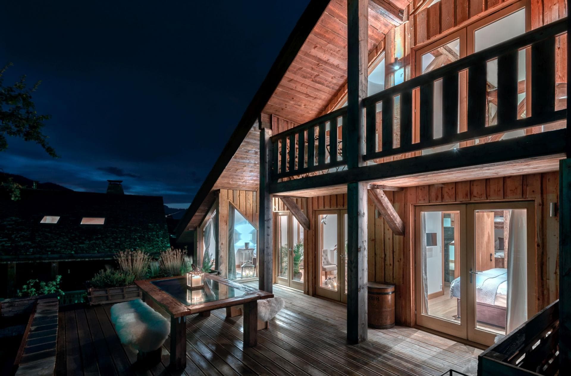Chalet exterior featuring wrap-around deck with outdoor dining and balcony access