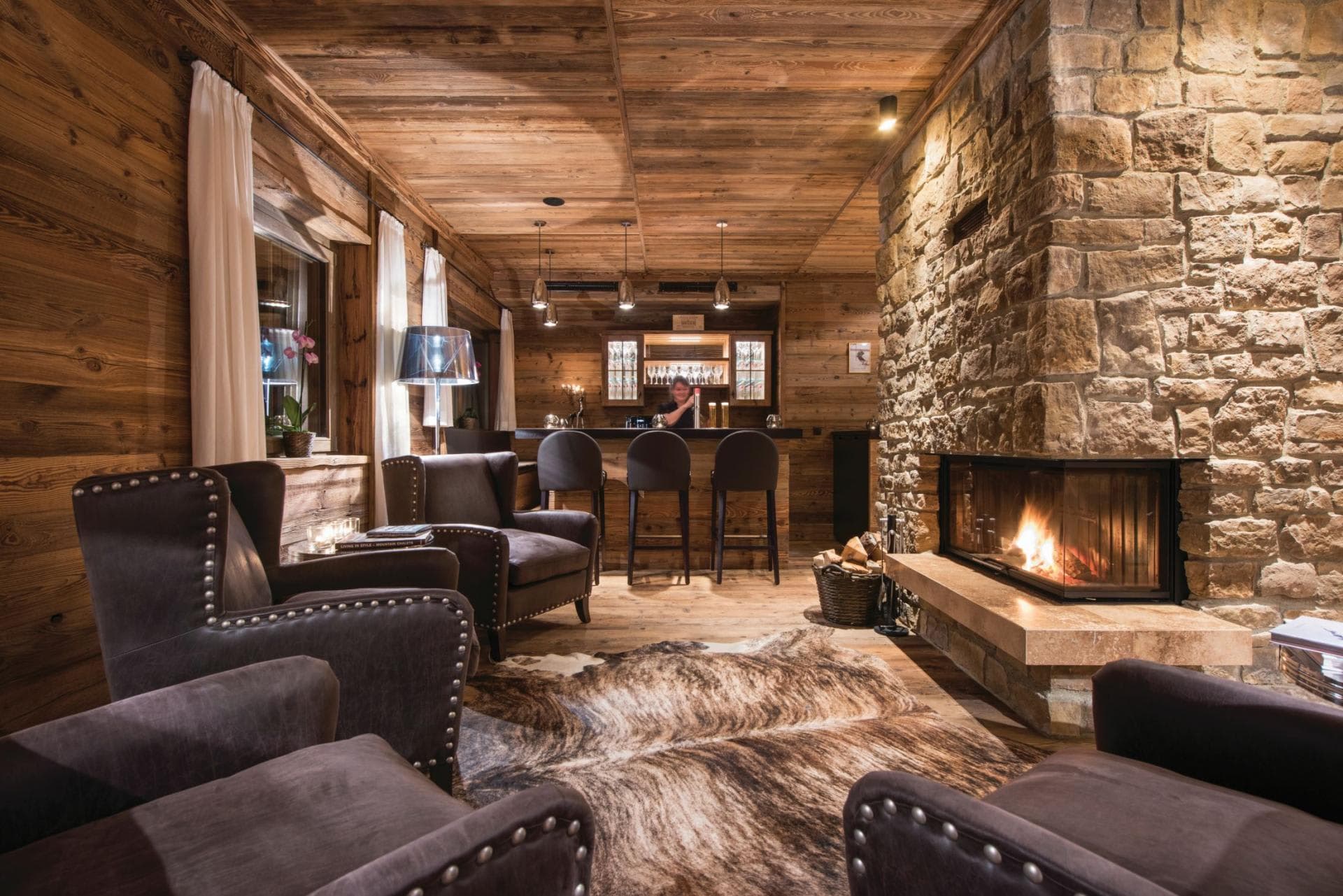 Lounge with wood-burning stone fireplace and three-seat wet bar