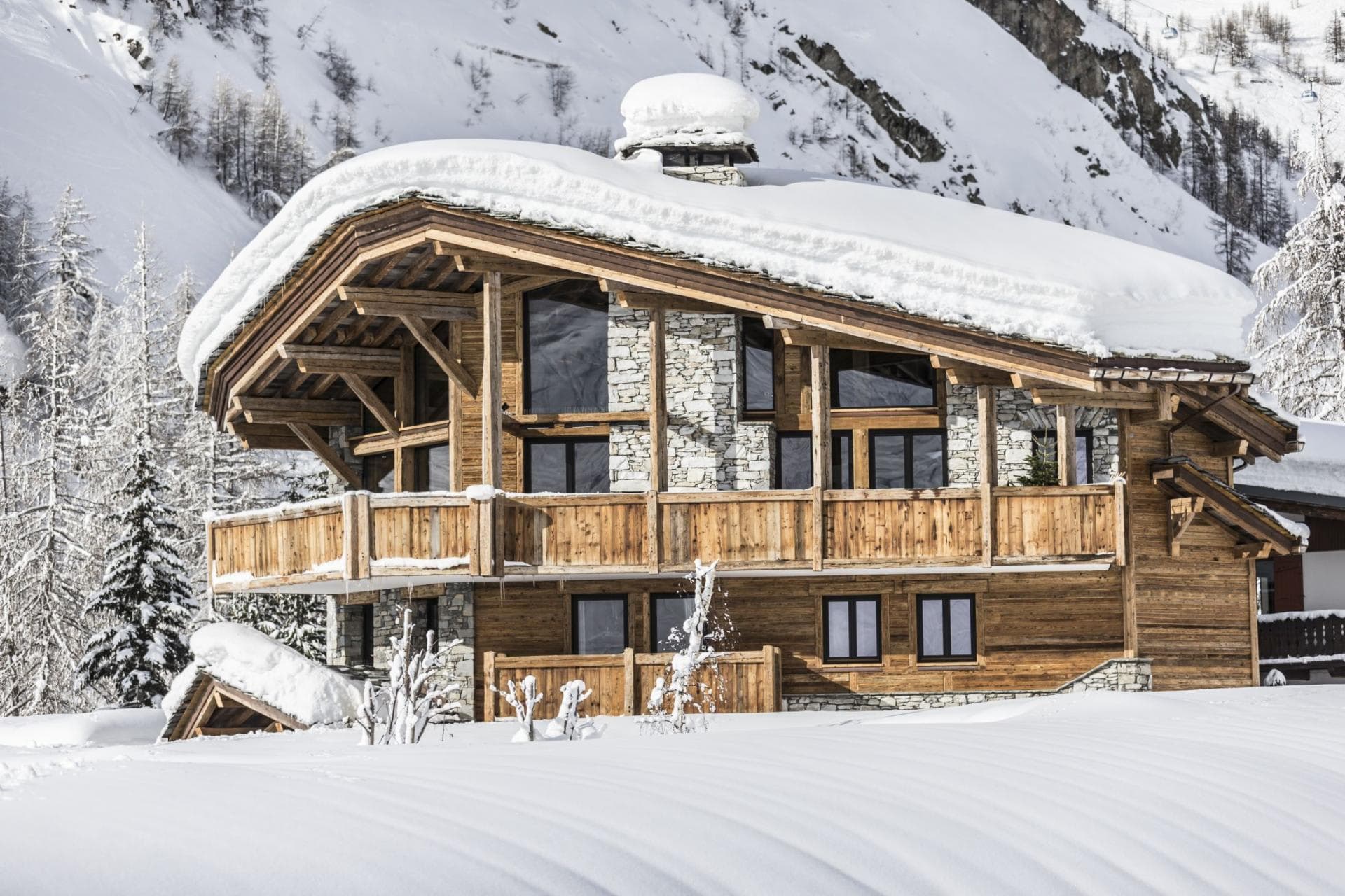 Ski-in chalet with wrap-around balcony and natural stone exterior
