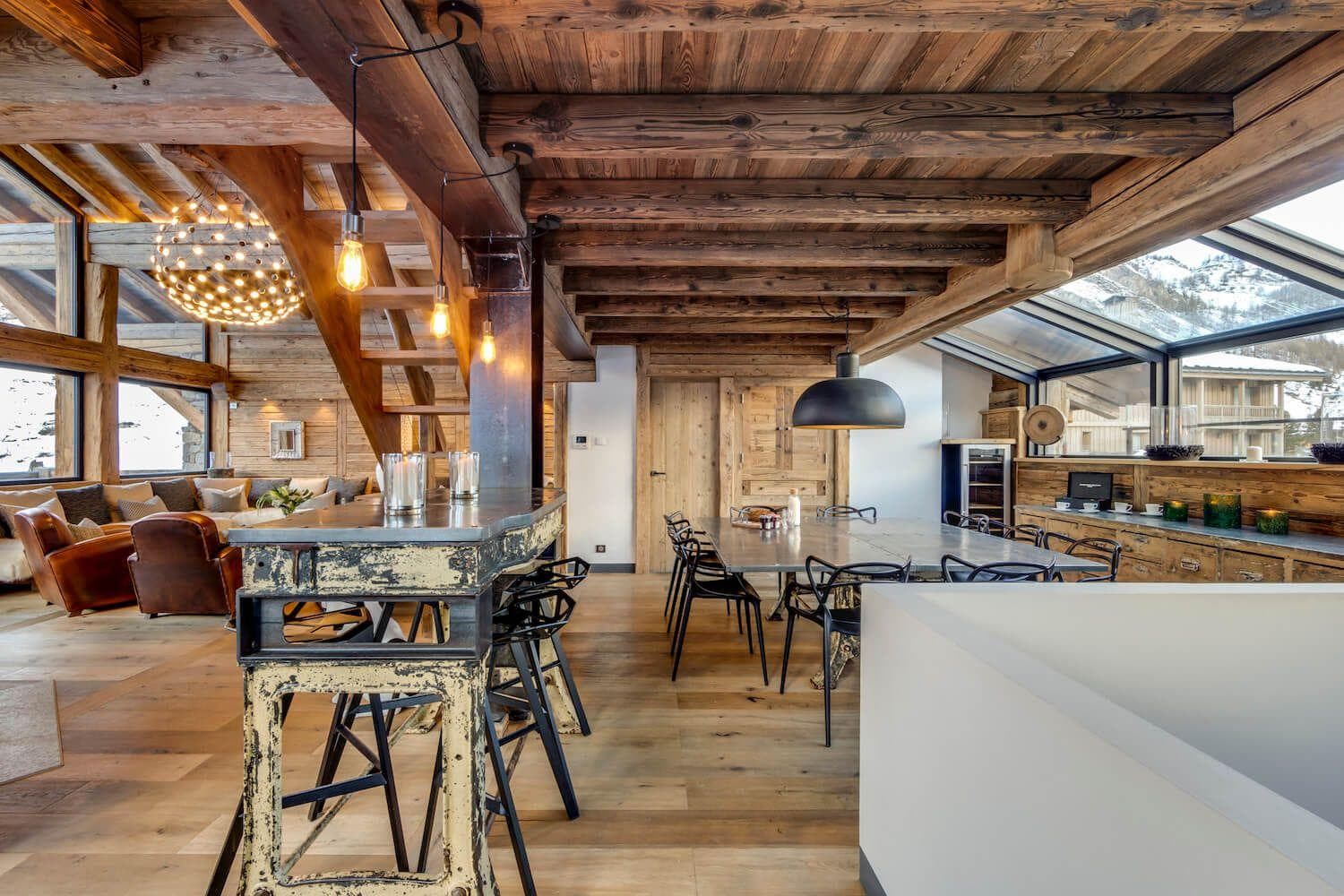 Open-plan dining area with 10-person table and mountain-view sunroom