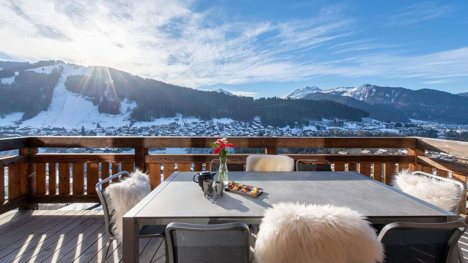 Private balcony with 6-person dining table and ski resort views