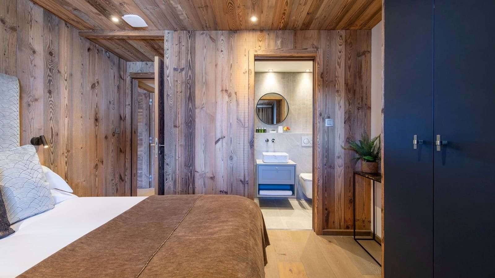 Wood-paneled bedroom with built-in wardrobe and ensuite bathroom