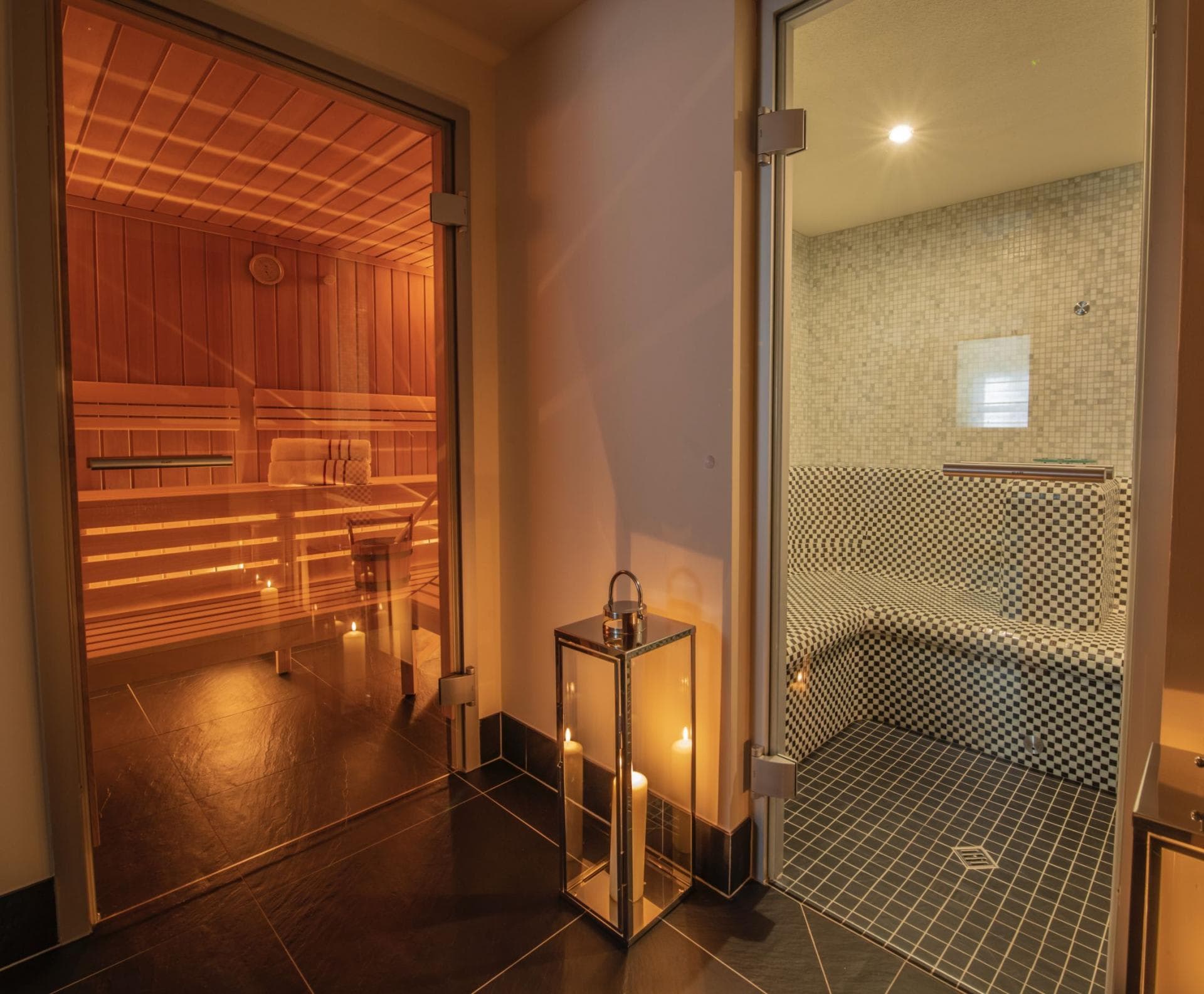 Private wellness area featuring wood-paneled sauna and mosaic-tiled steam room