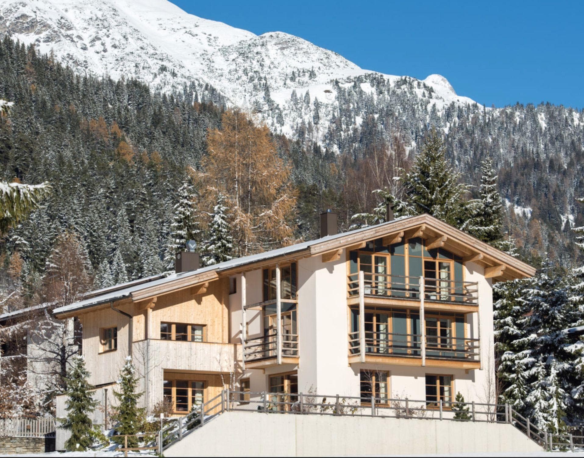 Chalet exterior with multiple private balconies and mountain backdrop