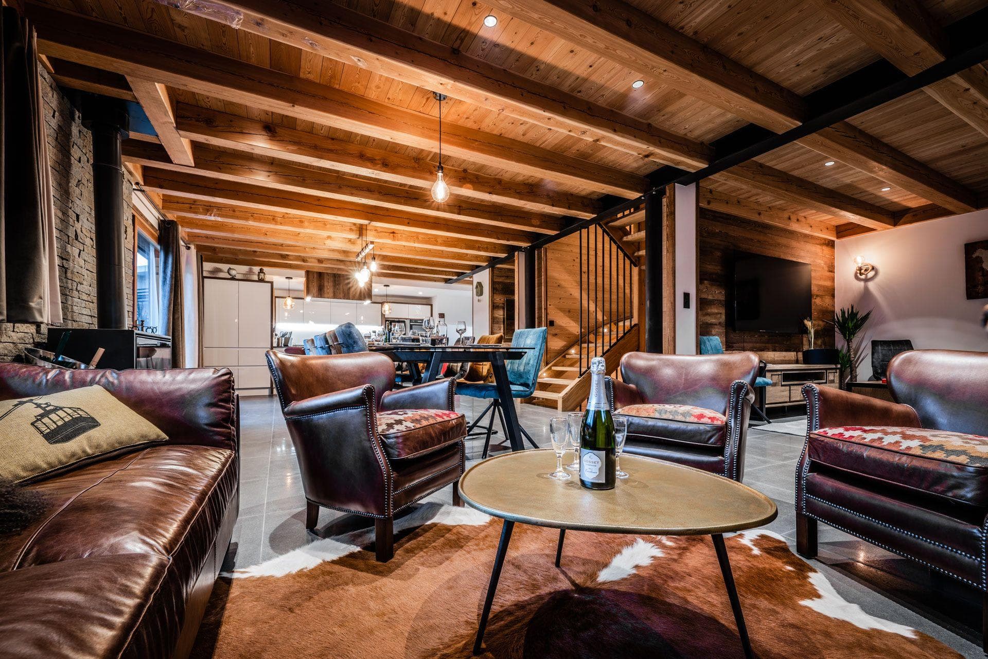 Open-plan living area with wood-beam ceilings and wood-burning stove