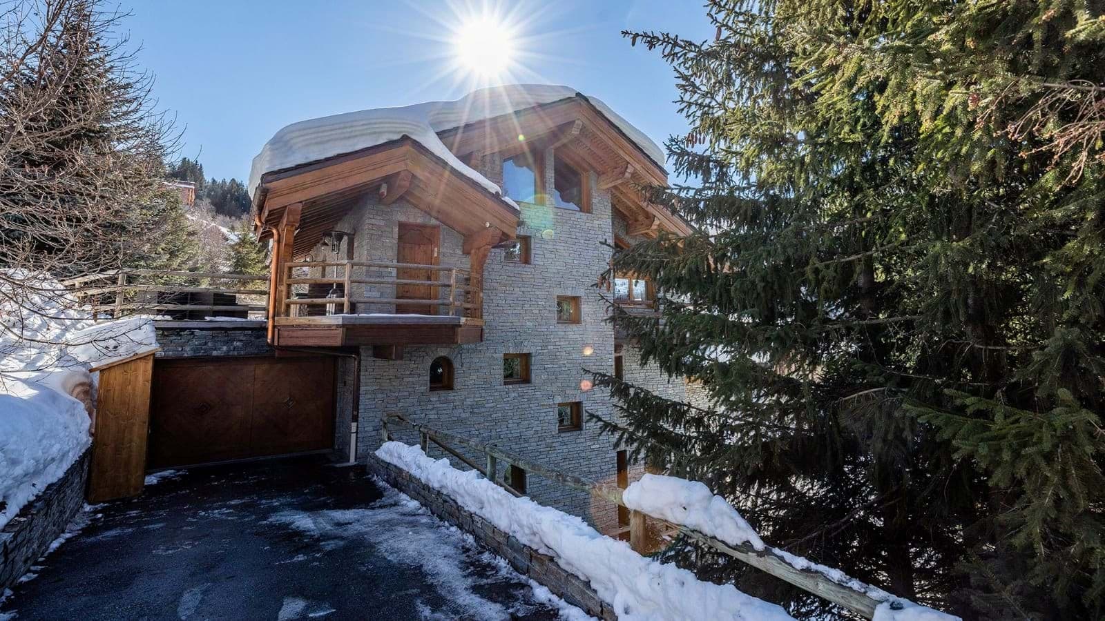 Stone-clad chalet exterior with heated driveway and integrated garage