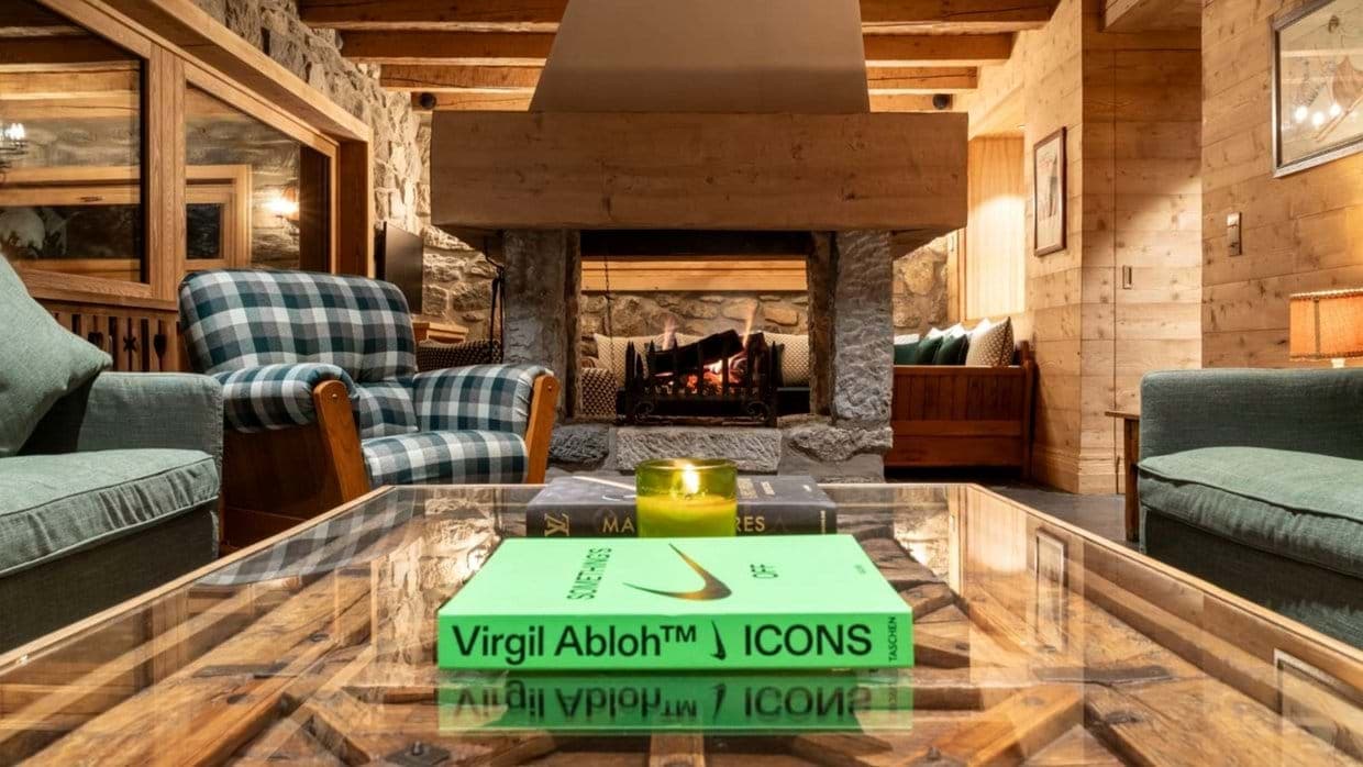Living area with central stone fireplace and exposed timber beams