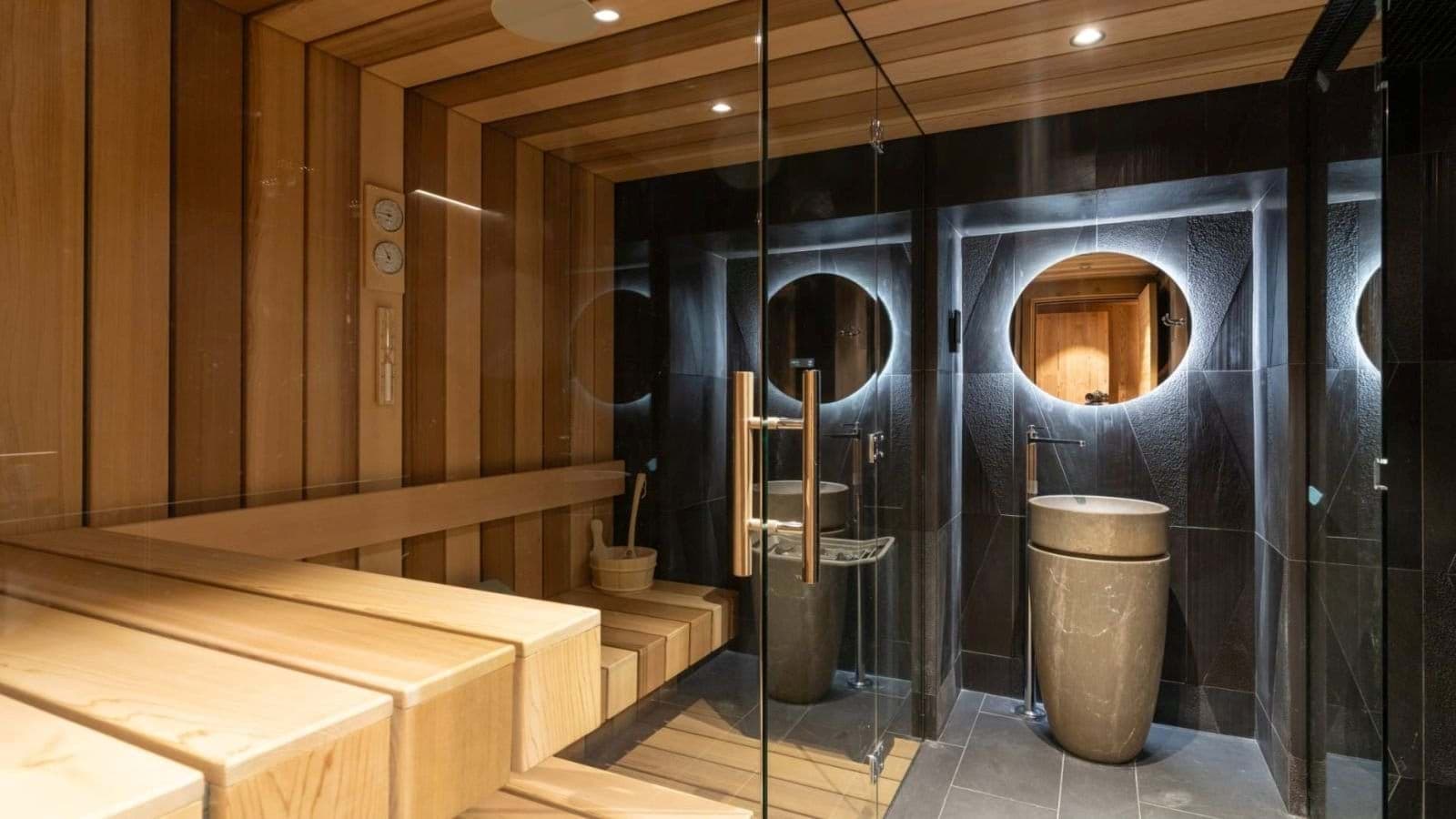 Private sauna with tiered seating and stone pedestal sink