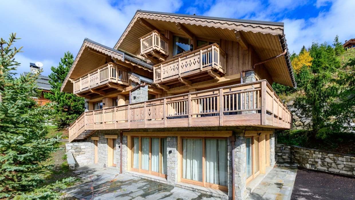 Multi-level timber chalet with wraparound balconies and stone terrace
