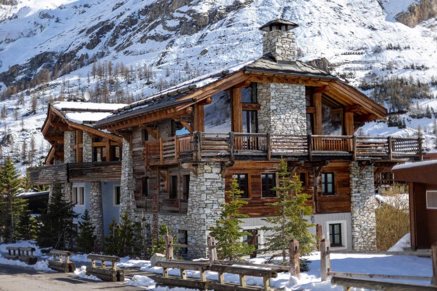 Ski-in chalet exterior with wrap-around balcony and mountain views