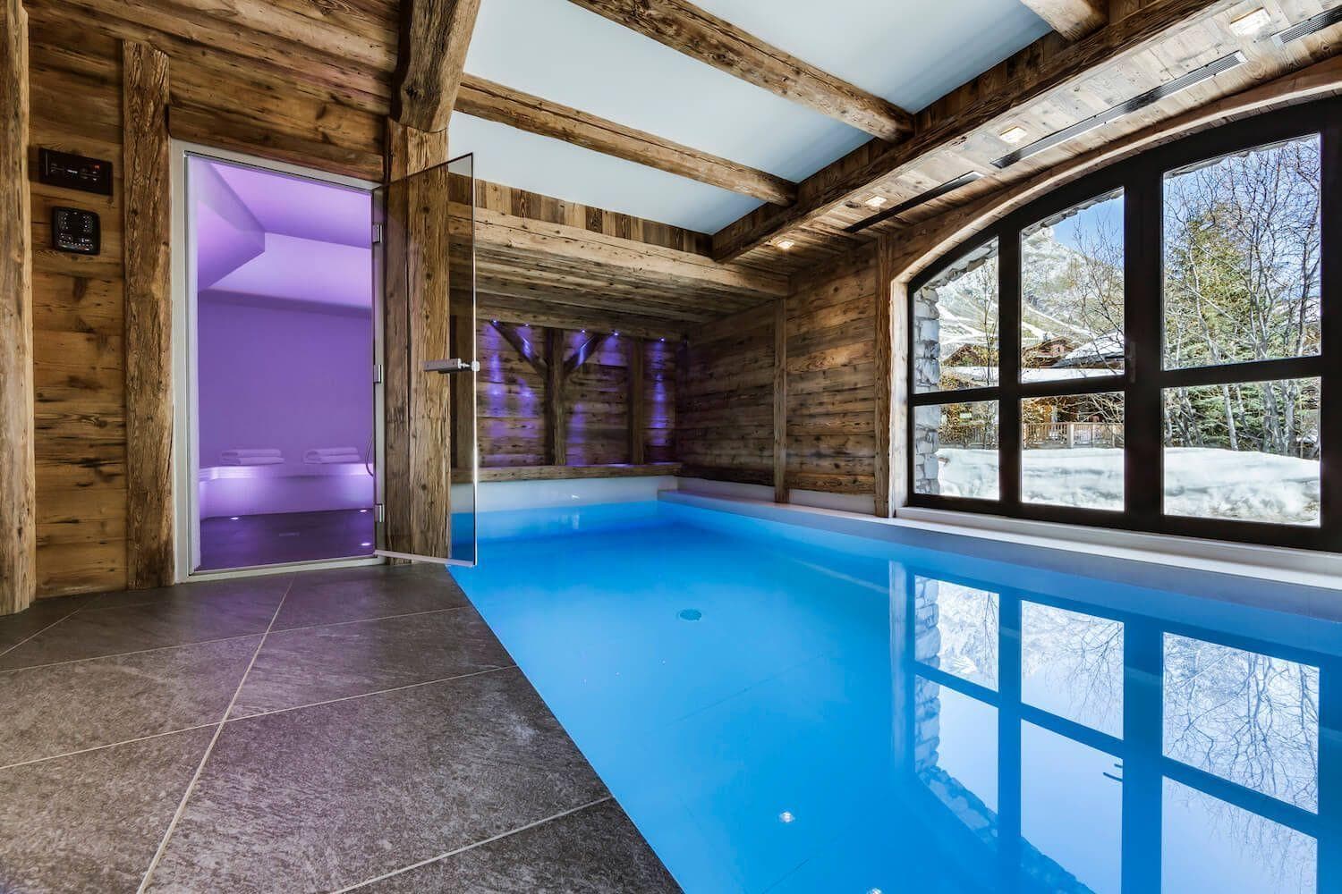 Indoor pool and steam room with mountain views and exposed timber beams