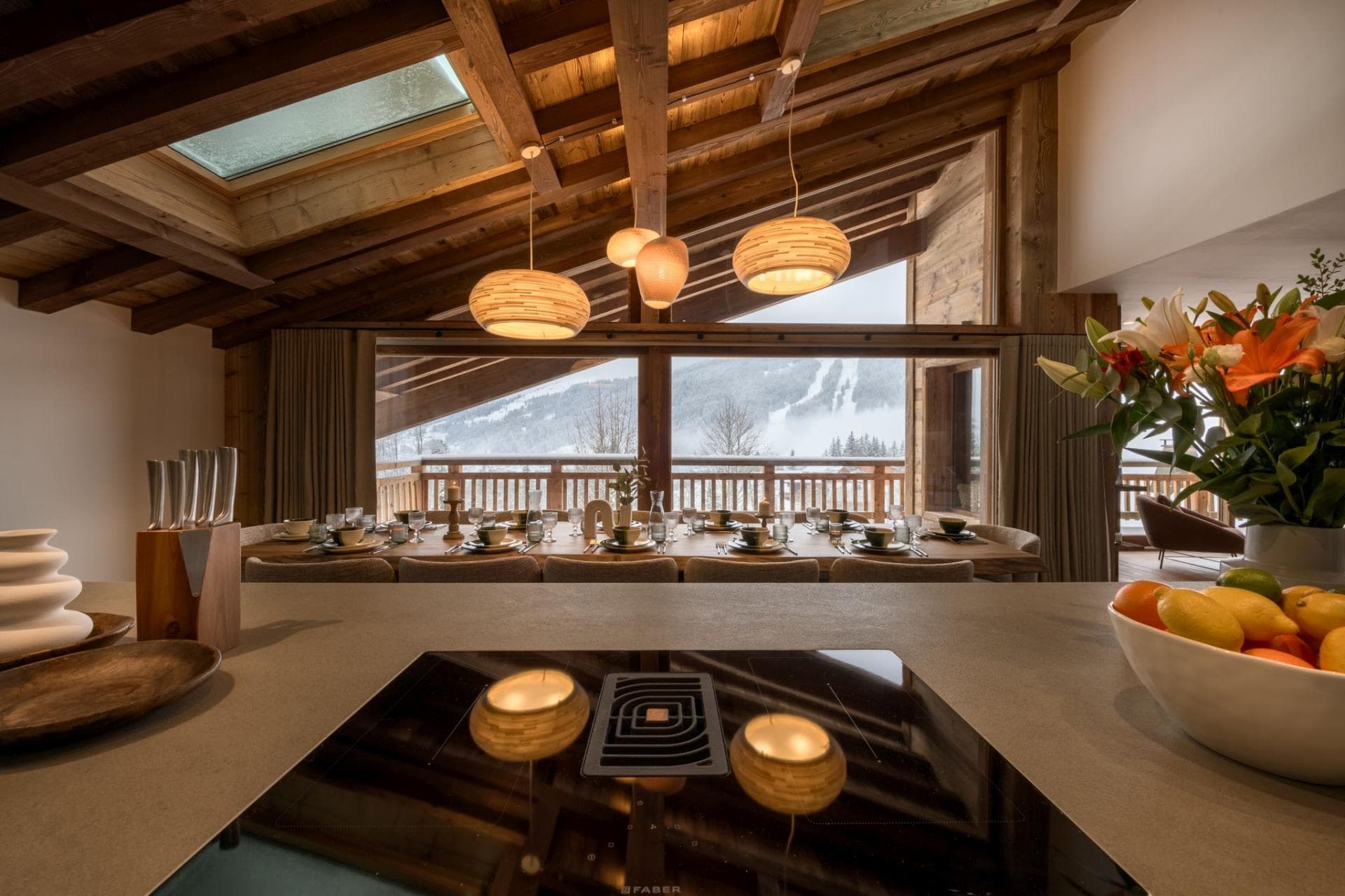 Open kitchen and dining area with induction cooktop and ski run views