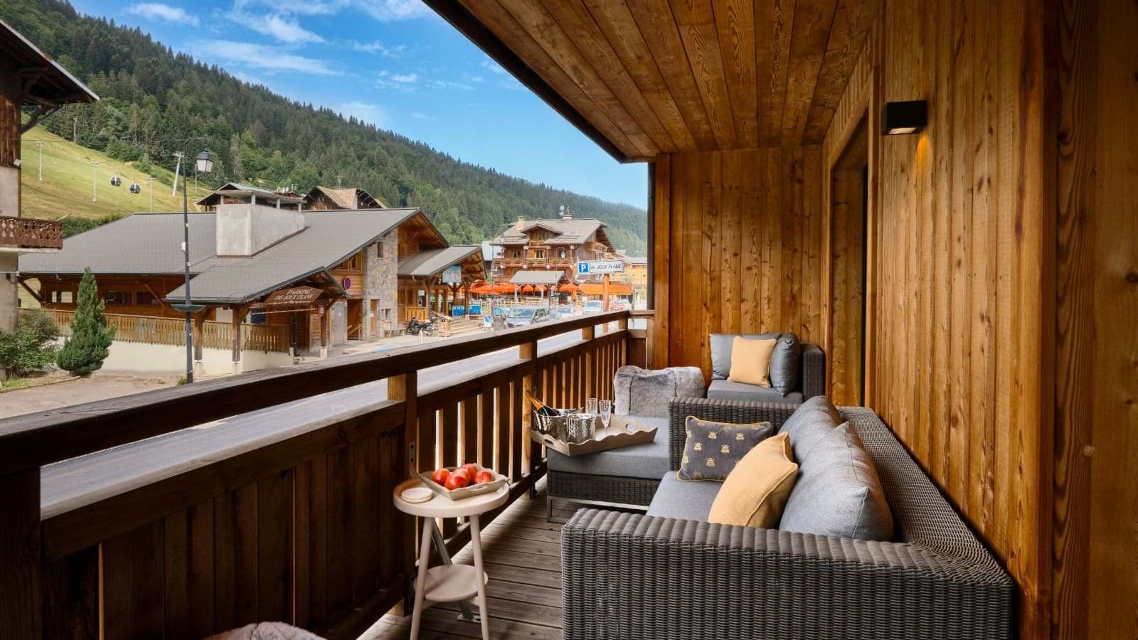 Covered balcony with sectional seating and views of the village ski slopes