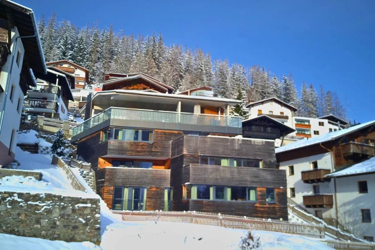 Chalet residence exterior in snow with timber balconies